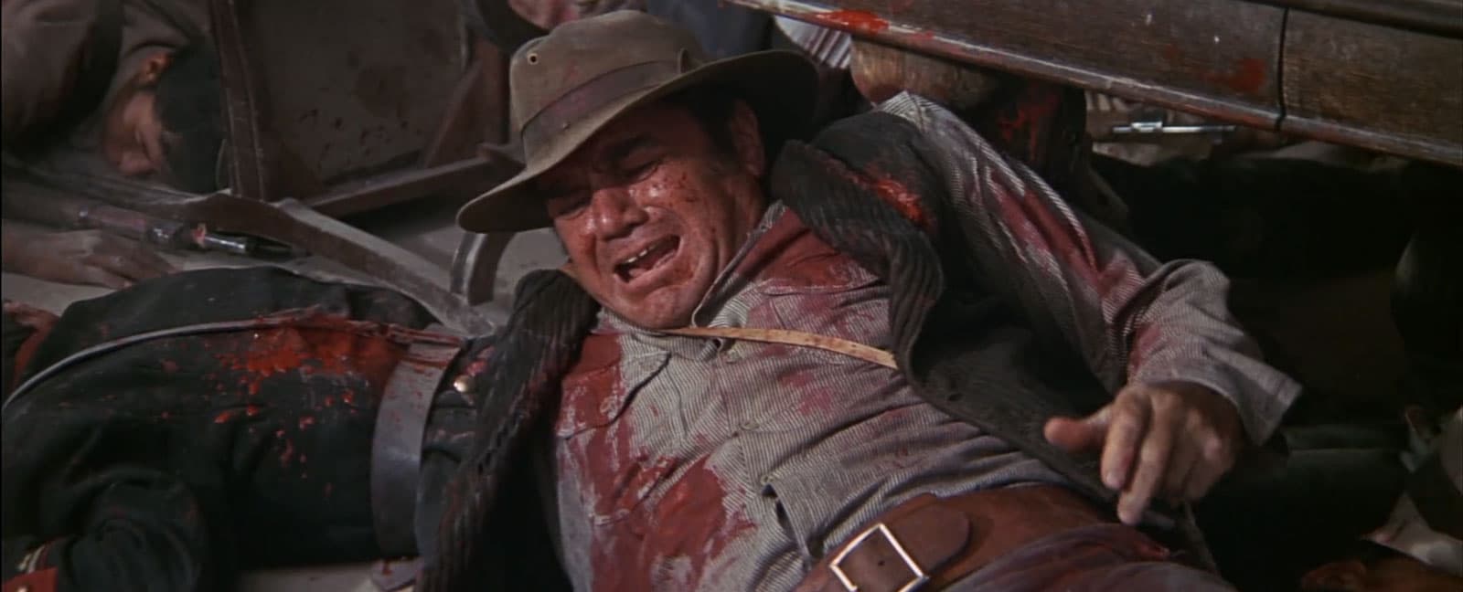 man covered in blood from gunfight